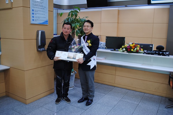 일일명예납세자보호담당관에 위촉된 이상원 원장이 51회 방문객에 기념품을 전달하는 모습입니다