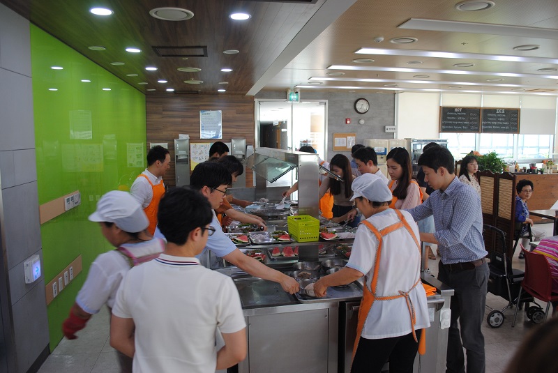 직원들이 어르신들의 식사를 퍼서 나르는 모습입니다.